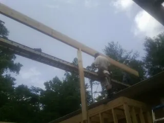 Carpenter setting a ridge beam over a new addition frame — Ice Dam Removal by Roofing Brothers in Atlanta